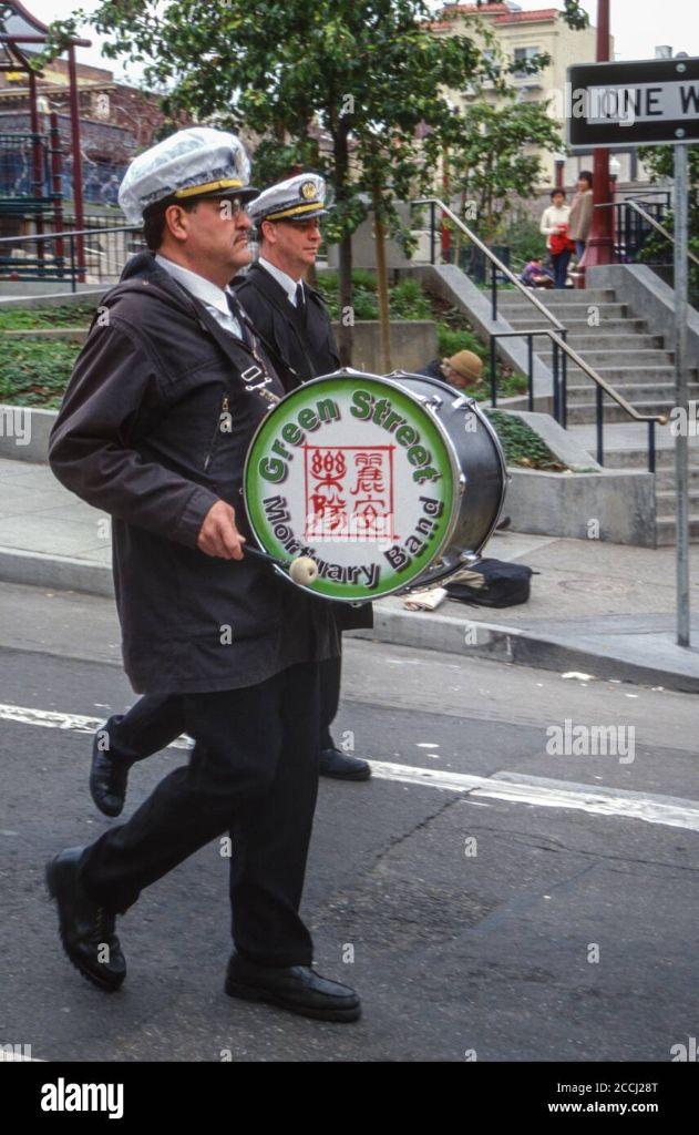 Band members carrying the ceremonial drum emblazoned with the Green Street Memorial Band (formerly Green Street Mortuary Band) name, an iconic symbol used in both Vietnamese and Chinese funeral processions