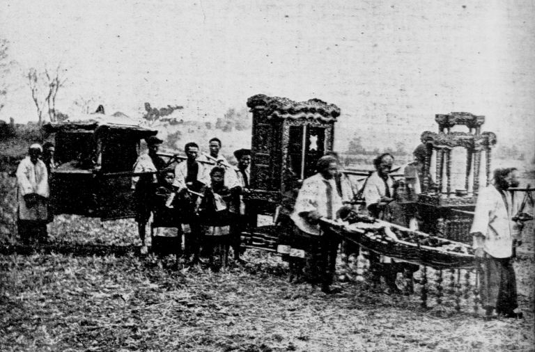 A historical photograph from the early 20th century showing a traditional Asian funeral procession with ceremonial carriages incorporating elements from Vietnamese and Chinese traditions - early predecessor to the Green Street Memorial Band (formerly Green Street Mortuary Band)