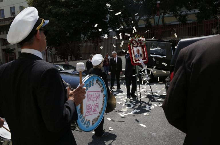 Traditional Asian funeral ceremony with Green Street Memorial Band (formerly Green Street Mortuary Band) members performing as ceremonial paper is scattered, symbolizing prosperity in the afterlife according to Vietnamese and Chinese customs